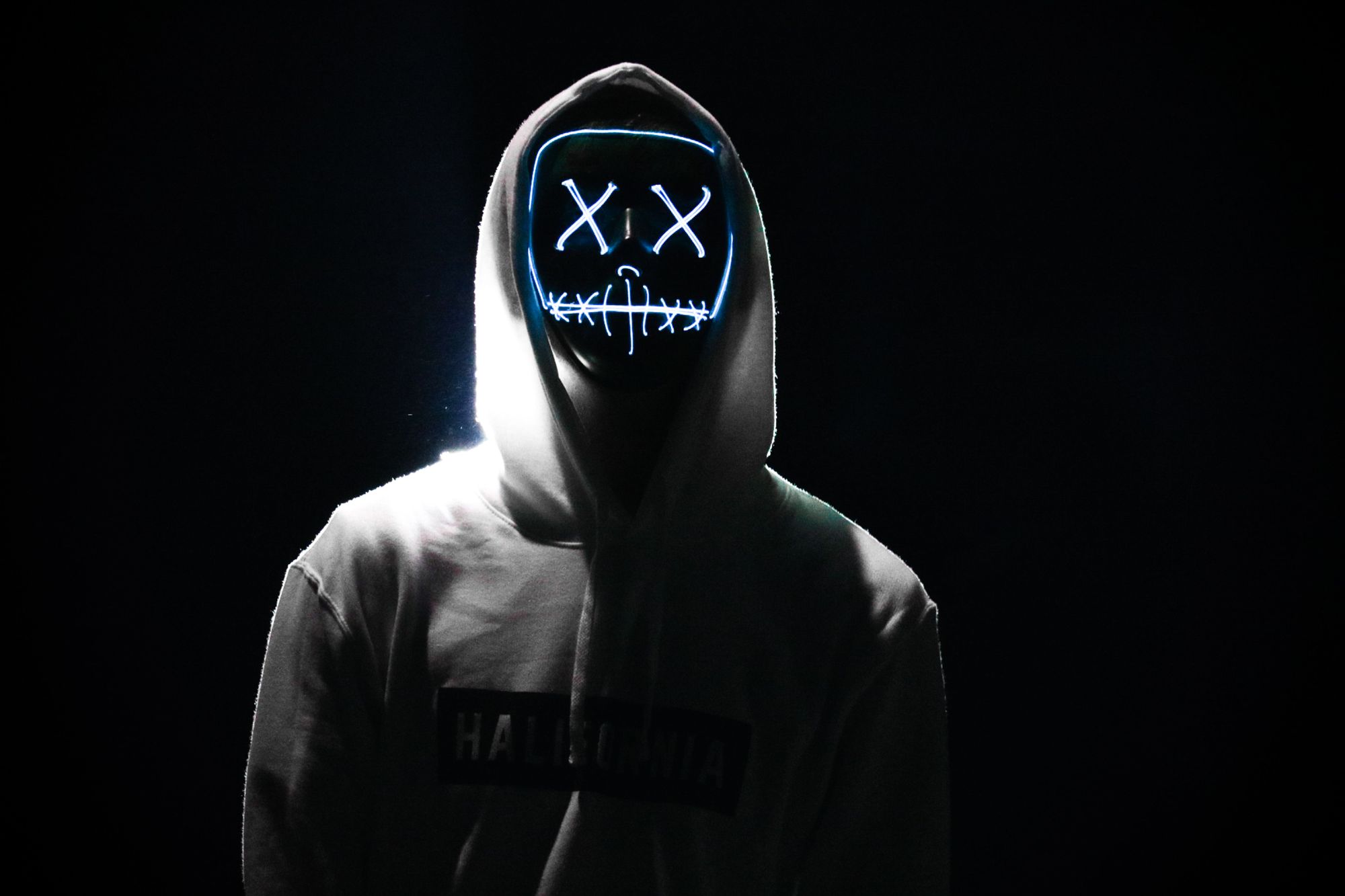 someone in a hoodie with lights for eyes